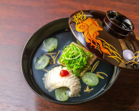 会席料理の煮物椀一例　牡丹鱧と肝豆腐　ジュンサイ　蓮　九条葱
